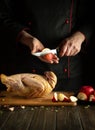 Professional chef cuts an apple before adding it to a raw duck for roasting in the oven. Cooking a national dish or Peking duck in Royalty Free Stock Photo