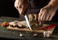 Professional chef cuts grilled beef meat on a cutting board. Work environment on the kitchen table with condiments or spices. Royalty Free Stock Photo