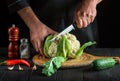 Professional chef cutting cauliflower in a restaurant kitchen. The idea of a delicious diet for breakfast or dinner Royalty Free Stock Photo