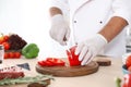 Professional chef cutting pepper on table