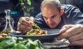 A professional chef decorates a meal just before serving it to a customer in a restaurant pub or hotel Royalty Free Stock Photo