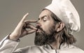 Professional chef man showing sign for delicious. Chef, cook making tasty delicious gesture by kissing fingers. Cook hat Royalty Free Stock Photo