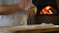 Professional chef prepares pizza dough. Flour in the hands of the cook.