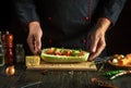 Professional chef prepares stuffed squash boats with minced meat and vegetables on the kitchen table. The concept of delicious