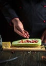 Professional chef prepares stuffed squash boats with minced meat and vegetables on the kitchen table. The concept of delicious