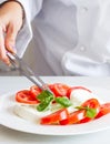 Professional chef preparing dish with tomatoes and mozzarella Royalty Free Stock Photo
