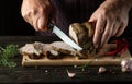 Professional chef slicing grilled beef meat on a cutting board. Work environment on the kitchen table with condiments or spices. Royalty Free Stock Photo