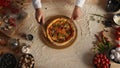 Professional chef slicing pizza by round cutter knife in restaurant kitchen. Royalty Free Stock Photo