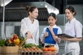Professional chef is teaching young culinary class student to prepare fresh ingredient for the meal inside the restaurant kitchen Royalty Free Stock Photo