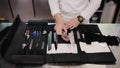 Professional chefs, cooking knife set in black case on the kitchen. Man's hands take knife from knives set. Professional