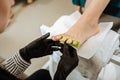 Professional chiropodist wearing striped blouse working hard