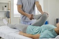 Professional chiropractor, osteopath or physiotherapist examining young woman& x27;s knee