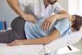 Professional chiropractor or physiotherapist helps to heal a young woman& x27;s back.