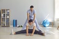 Professional chiropractor pushing and stretching man patients back as part of rehabilitation therapy