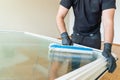 Professional cleaner using a washer sleeve to soap and clean a large fold-down window Royalty Free Stock Photo