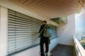 Professional cleaner vacuum cleaning window blinds on an apartment balcony in a high-rise building Royalty Free Stock Photo