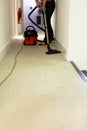 Professional cleaning service. Woman hoovering carpet in office