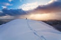 Professional climber on the snowshoeing at the top of the rock with his hands up is pleased with the next victory of the ascent an