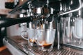 Fragrant espresso flows from a coffee machine into a cup. Making aromatic coffee with professional coffee equipment Royalty Free Stock Photo