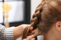 Professional coiffeuse braiding client`s hair in salon Royalty Free Stock Photo