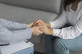 Professional compassion. Psychotherapist supporting depressed woman, holding her hands, sitting in clinic, cropped Royalty Free Stock Photo