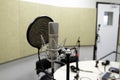 Professional condenser studio microphone over the musician blurred background and audio mixer, Musical instrument Concept.