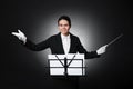 Professional conductor with baton and note stand on black background Royalty Free Stock Photo
