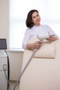 Professional Confident Female Doctor Posing in Doctor's Smock And Holding Intence Pulse Light Apparatus in Royalty Free Stock Photo