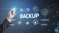 Businessman activating online backup with icons about security, recovery, restore and redundancy
