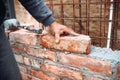 Professional construction worker laying bricks and building walls on industrial construction site. Detail of hand adjusting bricks Royalty Free Stock Photo