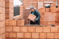 Professional construction worker laying bricks and building walls at industrial site Royalty Free Stock Photo