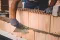 Professional construction worker laying bricks and mortar - building house wall Royalty Free Stock Photo