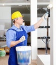 Professional construction worker priming and painting wall in repairable room with painting roller Royalty Free Stock Photo