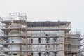 Professional construction workers on the scaffold elevator insulated wall facade with mineral wool. roofers wearing safety harness