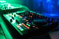 Professional control panel and mixing music under the green lights in nightclub at party