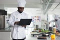 Professional cook wearing cooking uniform using computer to inspire for gourmet meal Royalty Free Stock Photo