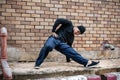 A cool Asian male hip-hop breakdancer is dancing on the street, showcasing his talented movements Royalty Free Stock Photo