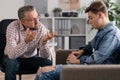 Professional counselor and troubled teenager during therapy meeting