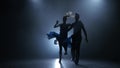 Professional couple of jive dancers posing in smoky studio, silhouette