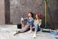 Professional couple sitting together on floor and discussing renovation home