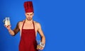 Professional culinary. Male cook in chef hat and apron holds glass jars with groats and cereals. Food preparation Royalty Free Stock Photo