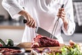 Professional cutlery used by a chef to cut red meat on a chopping board Royalty Free Stock Photo