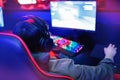 Professional cyber gamer studio room with personal computer armchair, keyboard for stream in neon color blur background