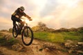 Professional Cyclist Riding Bike on the Autumn Rocky Trail at Sunset. Extreme Sport and Enduro Biking Concept. Royalty Free Stock Photo