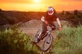 Professional Cyclist Riding the Bike on the Mountain Rocky Trail at Sunset. Extreme Sport