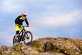 Professional Cyclist Riding the Bike on the Top of the Rock. Extreme Sport Concept. Space for Text. Royalty Free Stock Photo