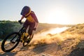 Cyclist Riding the Mountain Bike on the Summer Rocky Trail at the Evening. Extreme Sport and Enduro Cycling Concept.