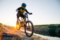 Cyclist Riding the Mountain Bike on the Summer Rocky Trail at the Evening. Extreme Sport and Enduro Cycling Concept. Royalty Free Stock Photo