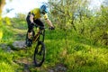 Professional Cyclist in Yellow T-shirt and Helmet Riding Bike Down Rocky Hill. Extreme Sport Concept. Royalty Free Stock Photo