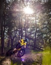 Professional Cyclist in Yellow T-shirt and Helmet Riding the Bike in Forest. Extreme Sport Concept. Royalty Free Stock Photo